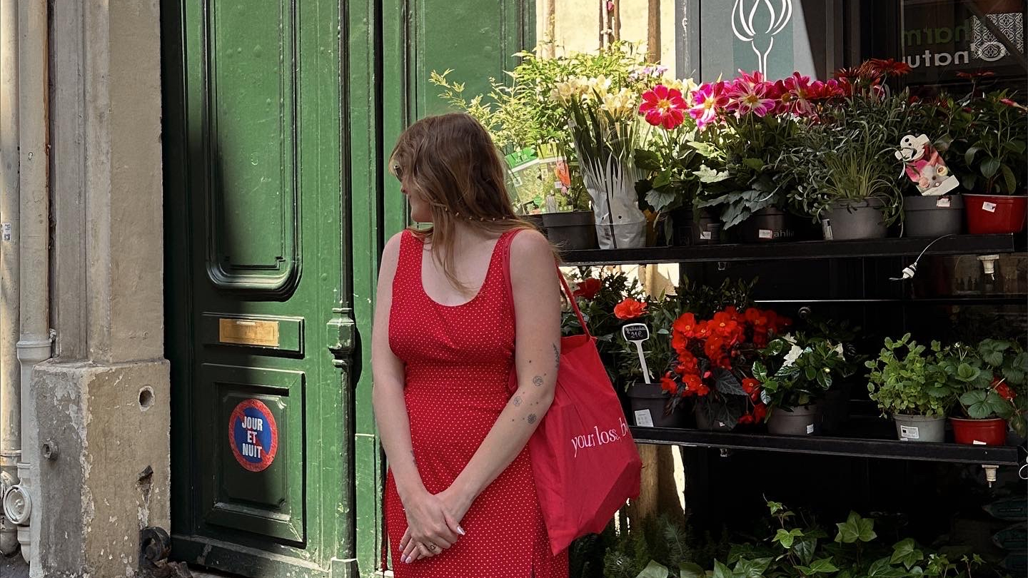 Juniper wearing a red dress looking over her left shoulder
